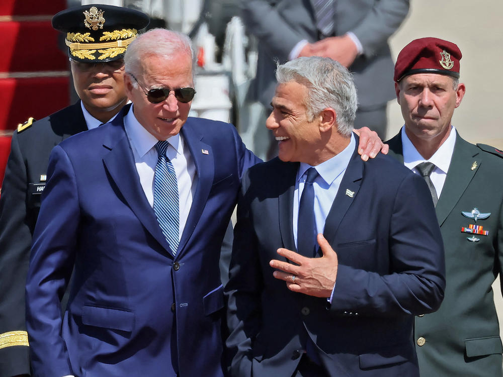 President Biden threw his arm around the shoulders of Israeli Prime Minister Yair Lapid after he arrived at Ben Gurion Airport in Tel Aviv.