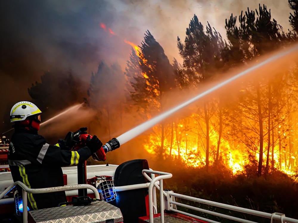 This photo provided by the fire brigade of the Gironde region shows firefighters battling a wildfire on Thursday near Landiras, in southwestern France.