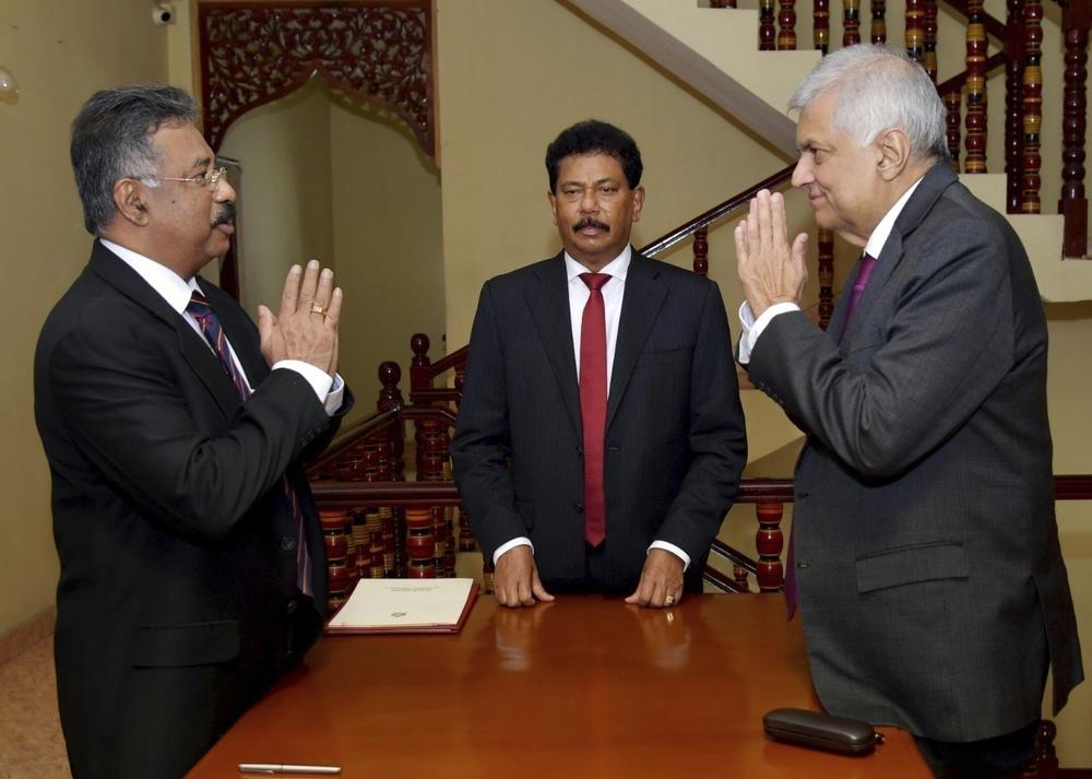 In this photograph provided by the Sri Lankan President's Office, interim President Ranil Wickremesinghe, right, greets Chief Justice Jayantha Jayasuriya during the oath-taking ceremony in Colombo, Sri Lanka, on Friday.