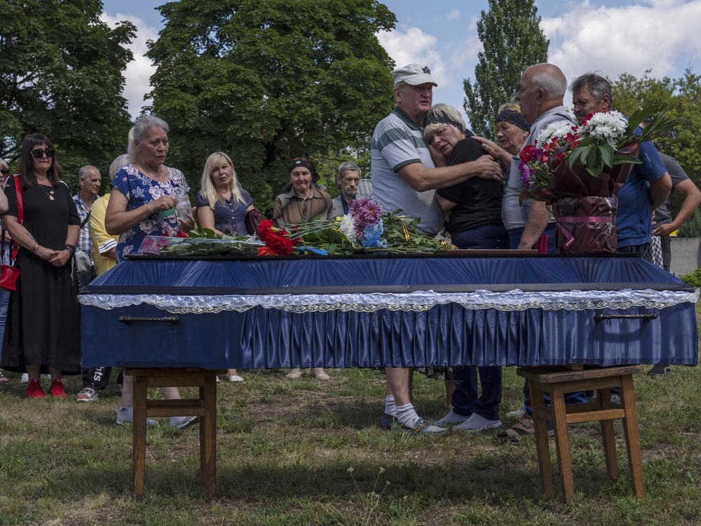 FILE The mother of 40-year-old Volodymyr Miroshnychenko who was killed on the frontlines of Marinka, weeps during his funeral procession at a cemetery in Pokrovsk, eastern Ukraine, Friday, July 15, 2022.
