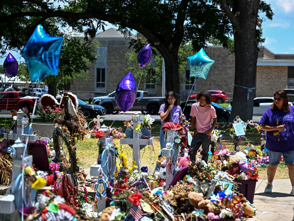 People visit a makeshift memorial to the victims of a shooting at Robb Elementary School outside the Uvalde County Courthouse on June 30.
