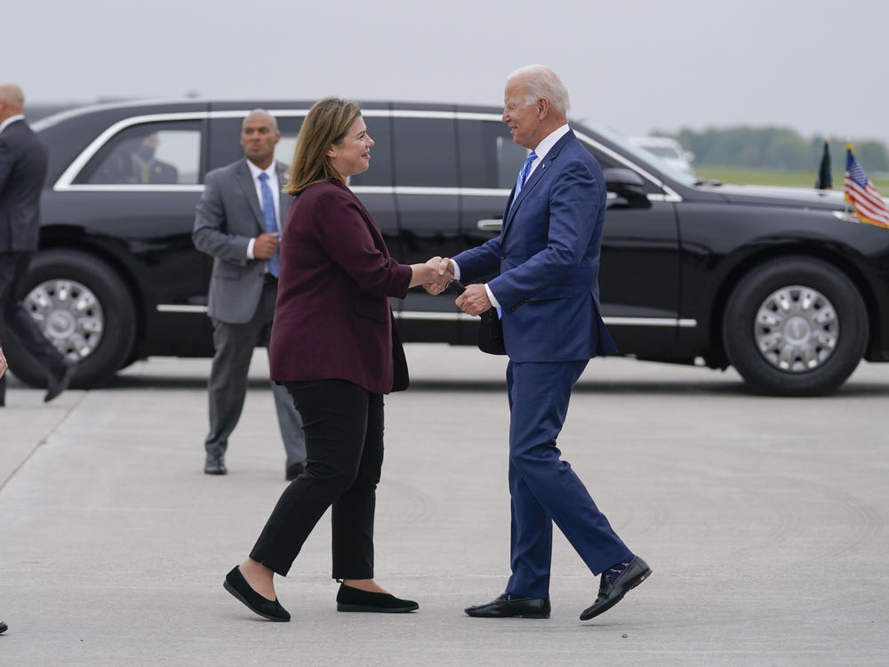 President Biden shakes hands with Rep. Elissa Slotkin, D-Mich., as he arrives at the airport in Lansing, Mich., on Oct. 5, 2021.