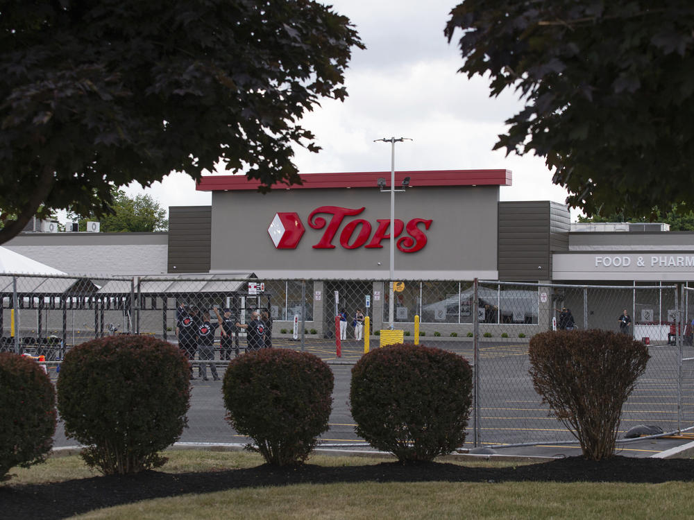 People stand in the parking lot of the Tops Friendly Market last week in Buffalo, N.Y., last week.