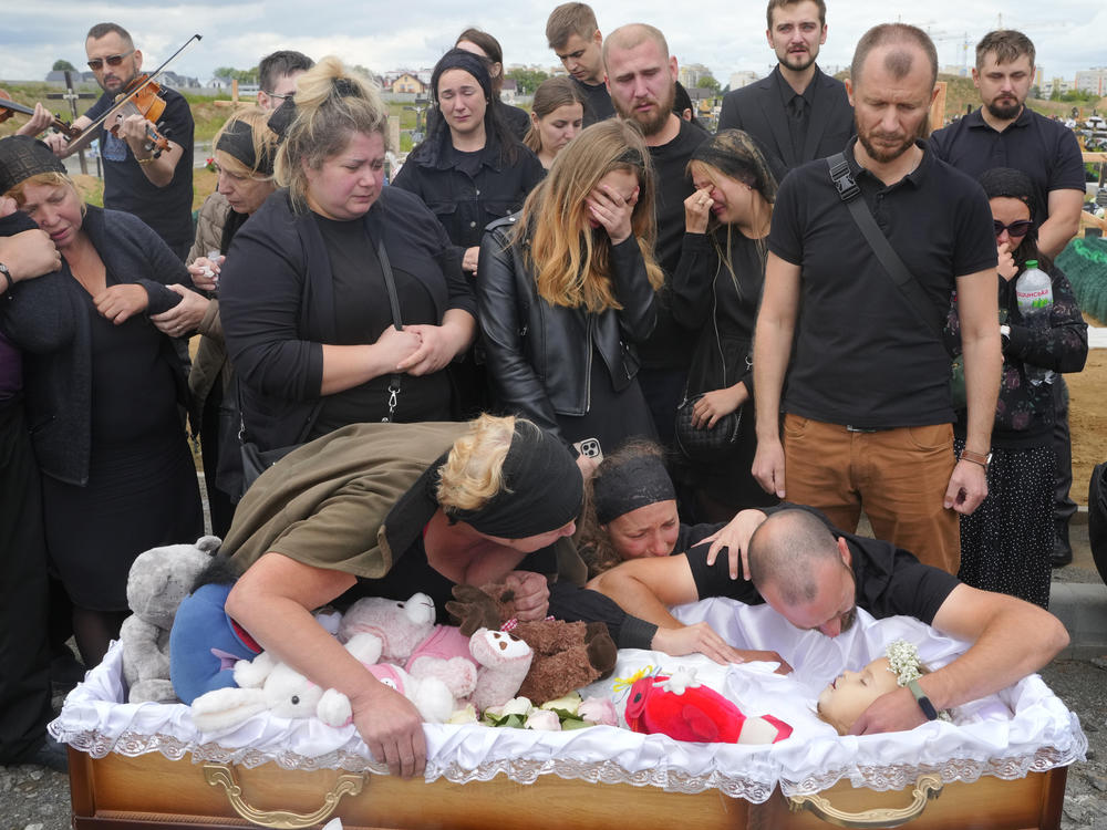 Relatives and friends attend the funeral on Sunday for Liza, a 4-year-old girl killed by Russia's attack on Vinnytsia, Ukraine. The girl was among 23 people killed in Thursday's missile strike in Vinnytsia. Her mother, Iryna Dmytrieva, was among the scores injured.