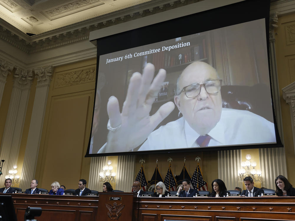 Rudy Giuliani's videotaped testimony appears on a video screen above members of the Select Committee to Investigate the January 6th Attack on the U.S. Capitol during its seventh hearing on July 12, 2022.