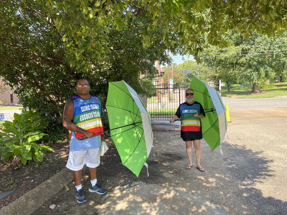 Mia Raven and another staff member of Powerhouse with umbrellas they used to escort patients.