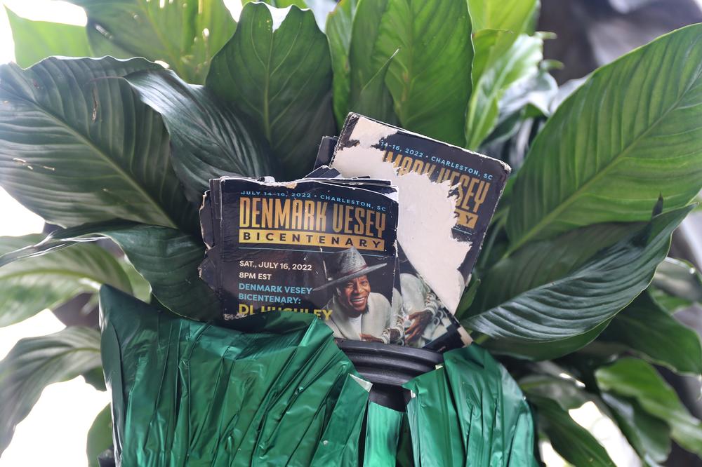 A peace lily left at the base of the Denmark Vesey statue with a program promoting the 200th anniversary of his efforts and his life.