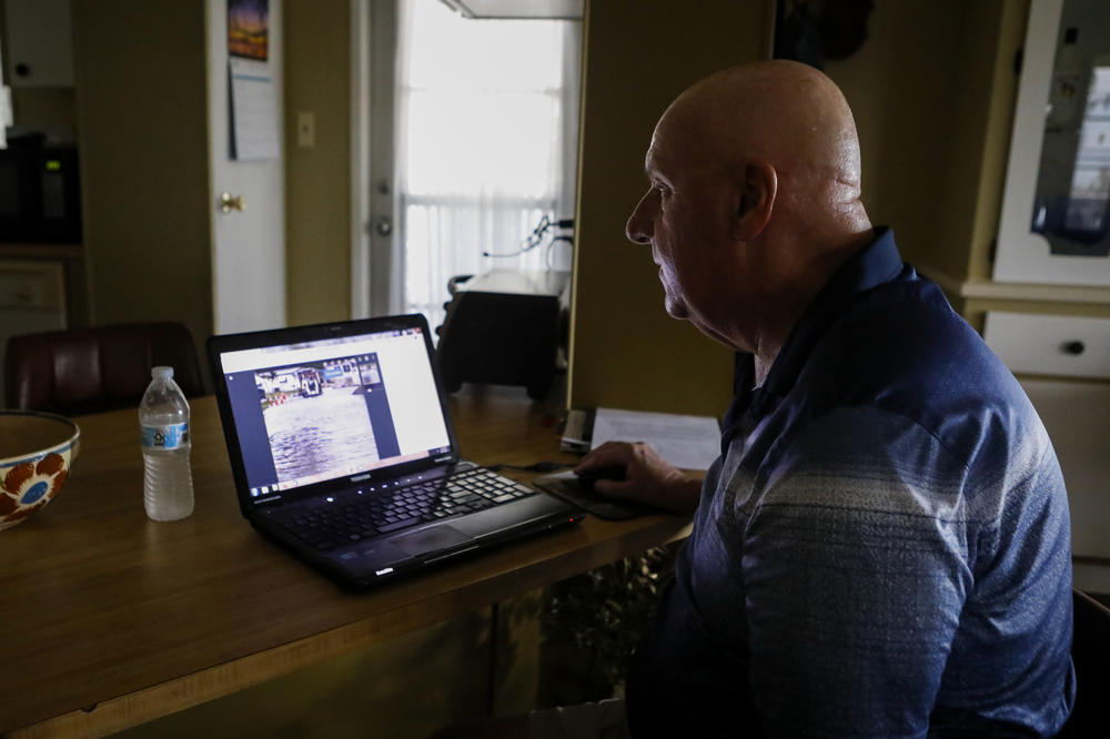 Mike Noel looks at photos from his archive of the floods on Heritage Plantation streets, Wednesday, June 8, 2022, in Vero Beach.