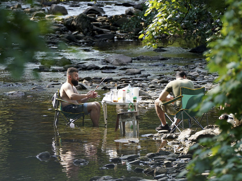 People escape the heatwave by taking a barbecue in a river near the village of Luss in Argyll and Bute on the west bank of Loch Lomond, Scotland, Monday July 18, 2022.