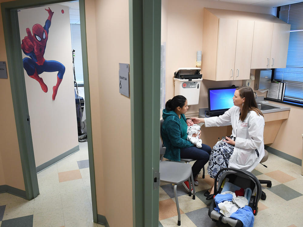 Ana Elsy Ramirez Diaz holds her baby as he is seen by Dr. Margaret-Anne Fernandez during a checkup visit at INOVA Cares Clinic for Children in Falls Church, Va. A portion of the clinic's patients are insured through the Children's Health Insurance Program.