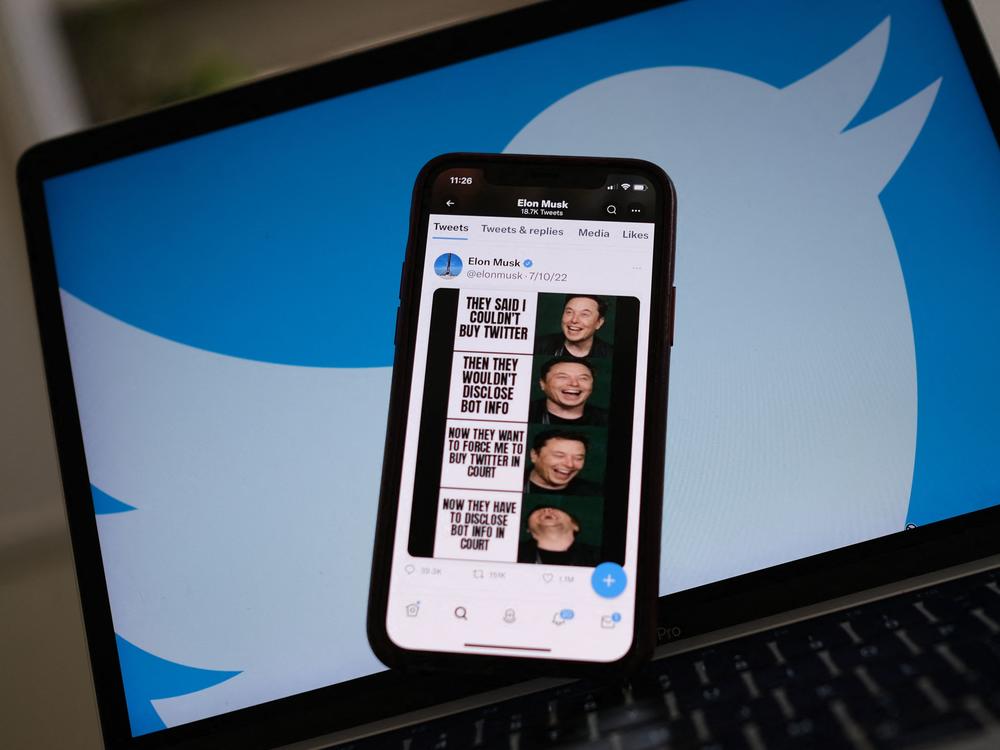 Elon Musk's tweets mocking Twitter's lawsuit are displayed on a smartphone with Twitter logo in the background in this illustration photo taken on July 18, 2022.