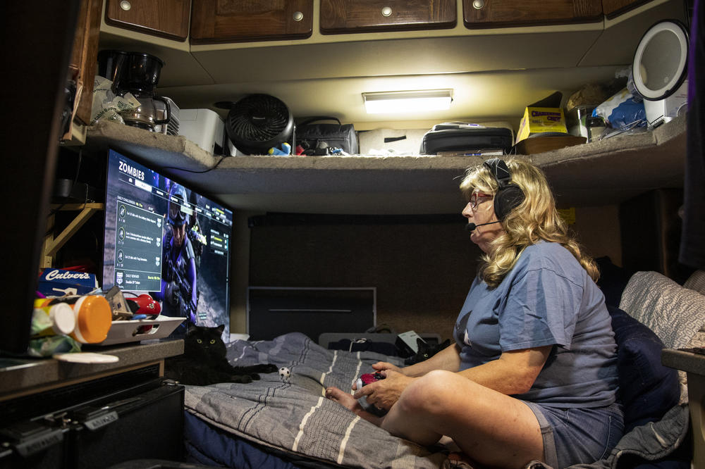Brandie plays video games in the cab of her truck. She often plays virtually with her daughter.