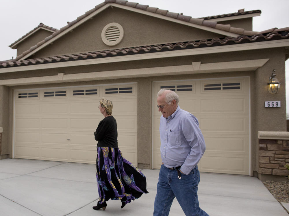 In this Friday, April 13, 2012 photo, Kelly, left, and Bill Noorish walk around a model a Lennar Next-Gen multigenerational home, in Las Vegas.