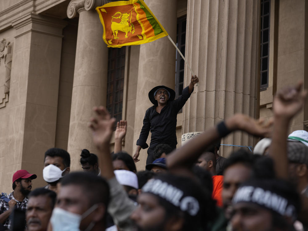 A protester waves a national flag and shouts slogans demanding elected president Ranil Wickremesinghe step down during a protest at the presidential secretariat premise on Wednesday.