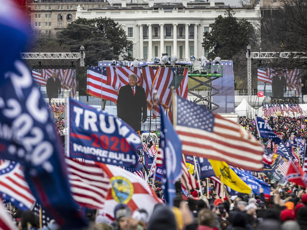 Supporters cheer as President Donald Trump addresses them during a rally on Jan. 6, 2021. A NPR/<em>PBS NewsHour</em>/Marist poll found that a majority of respondents blame Trump for the attack on the Capitol that followed the rally, but that a slightly larger majority don't think he'll face charges.