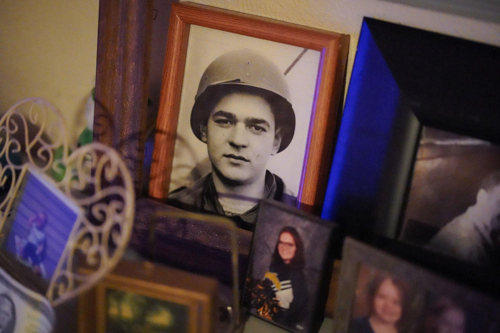 A photograph of Kathy Stolz-Silvis's father, Paul Andrew Stolz, who passed away when she was nine, is displayed among other family pictures in her home in Corry, Pa., in July.