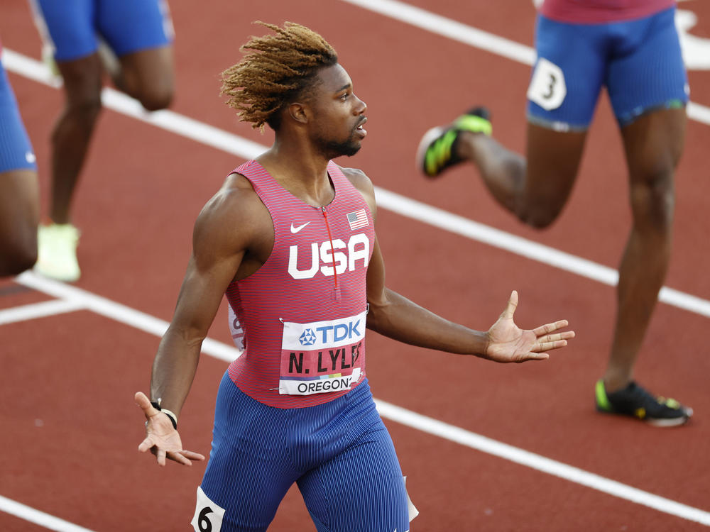 Noah Lyles celebrates winning gold in the men's 200m — and checks his record time — at the World Athletics Championships at Hayward Field in Eugene, Ore.