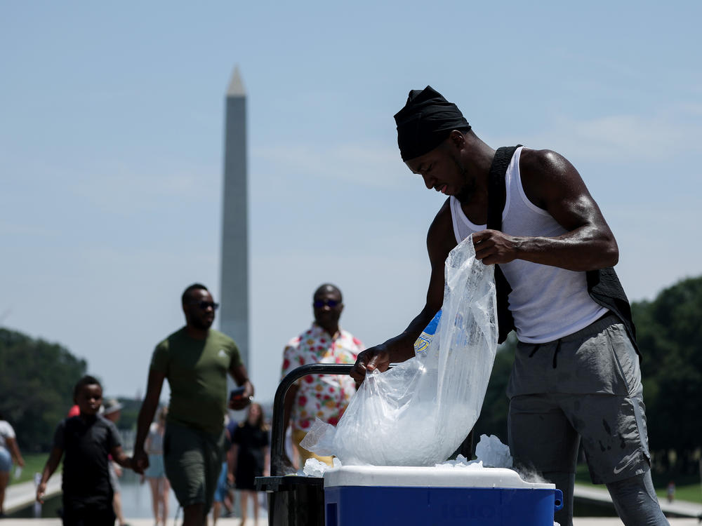 A vendor fills a cooler with ice during a heat wave in front of the Lincoln Memorial on Friday in Washington, D.C.