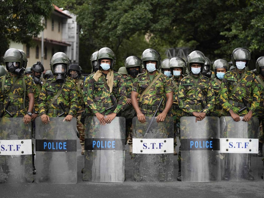 Police commandos stand guard at a barricade outside president's office in Colombo, Sri Lanka, on Friday.