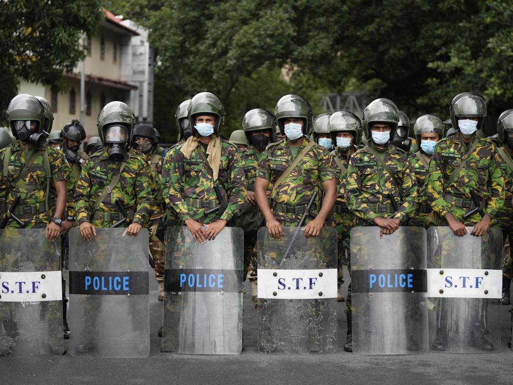 Police commandos stand guard at a barricade outside president's office in Colombo, Sri Lanka, on Friday.