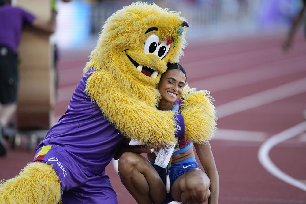 McLaughlin, of the United States, and Legend the Bigfoot mascot embrace after her race.