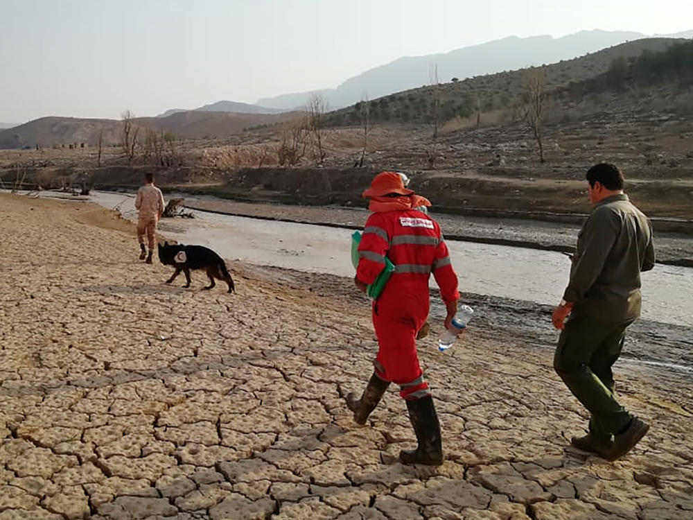 Members of a rescue team on Saturday search for missing people from flash floods in Iran's drought-stricken southern Fars province.