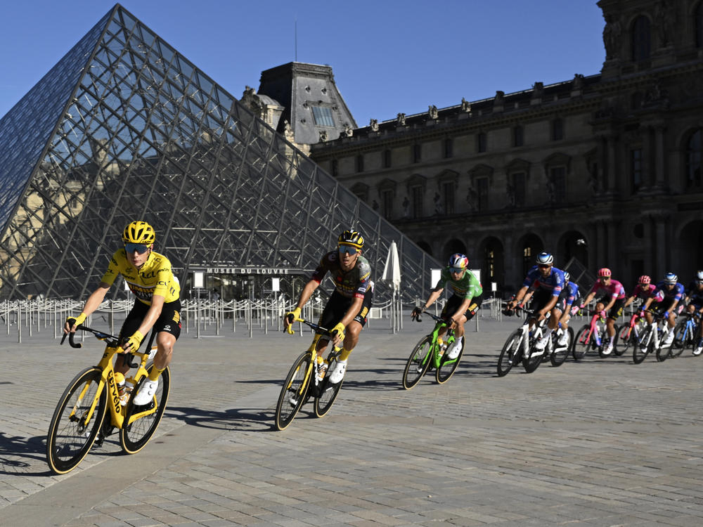 The pack with Denmark's Jonas Vingegaard, wearing the overall leader's yellow jersey, passes the Louvre Museum during the 21st stage of the men's Tour de France cycling race.