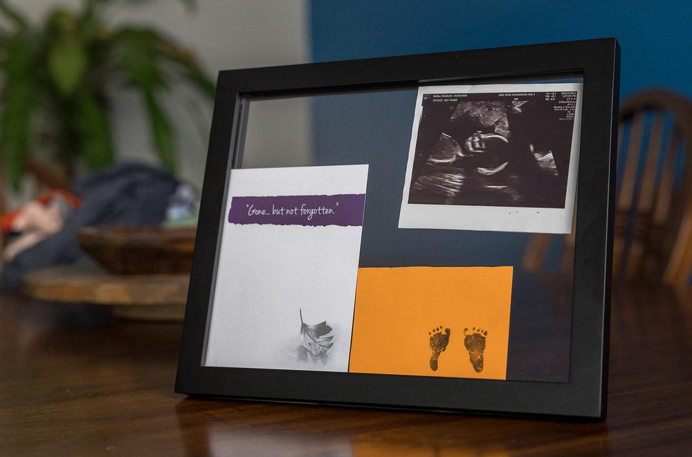 Elizabeth and James keep remembrances of their baby in a picture frame at home.