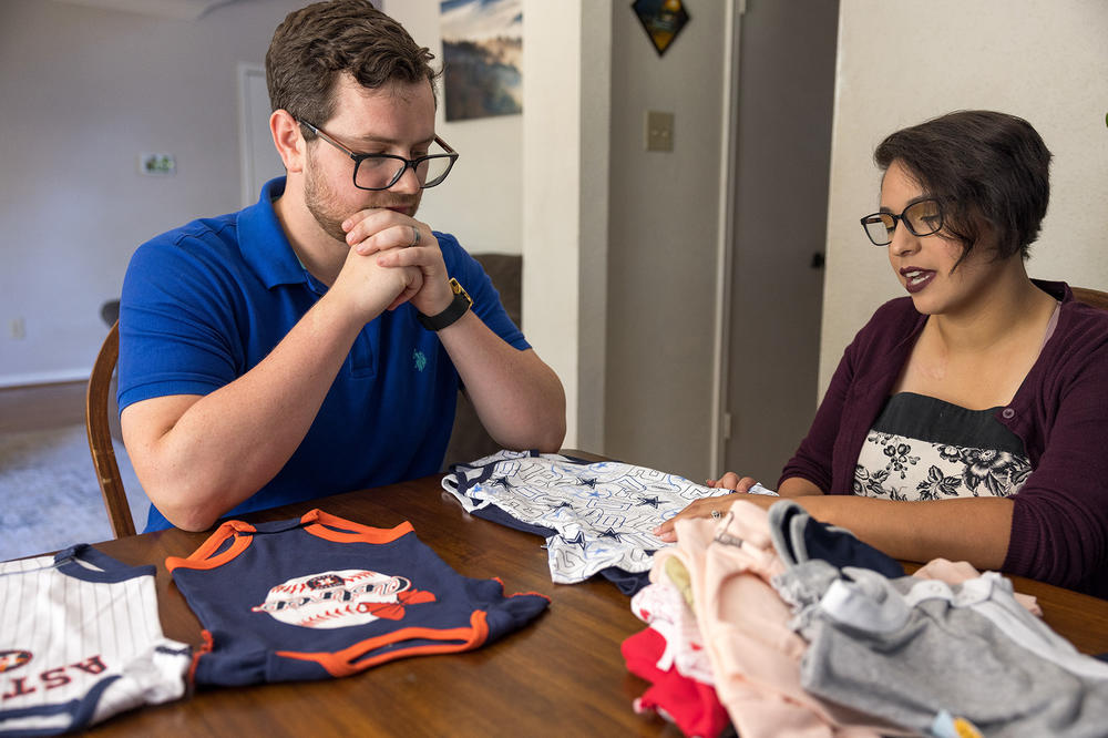 Elizabeth and James look at clothes that were meant for their baby, whom they lost in the second trimester of pregnancy.