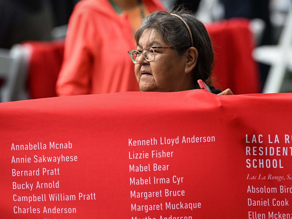 A member of the Indigenous community helps display the memorial banner, which was the first national, public record of the names of the children who did not return home from the residential schools across Canada.