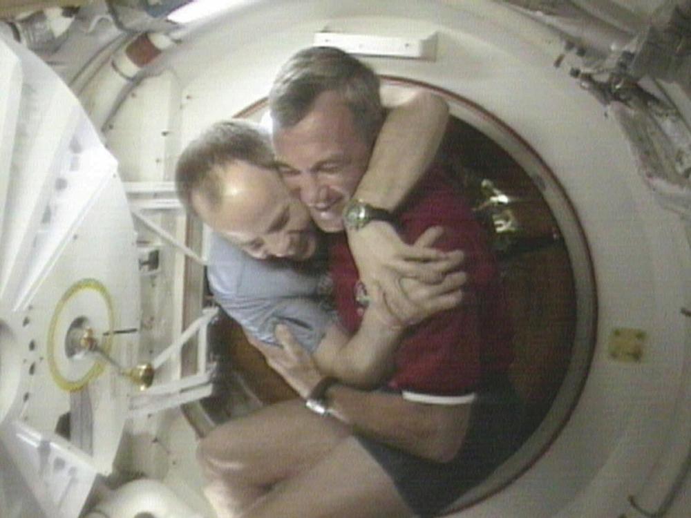 U.S. Space Shuttle Commander Terrence Wilcutt (right) and Mir Commander Anatoly Solovyev hug after opening the hatches between the space shuttle Endeavour and the Russian Space station Mir Saturday, Jan. 24, 1998, in this image from television