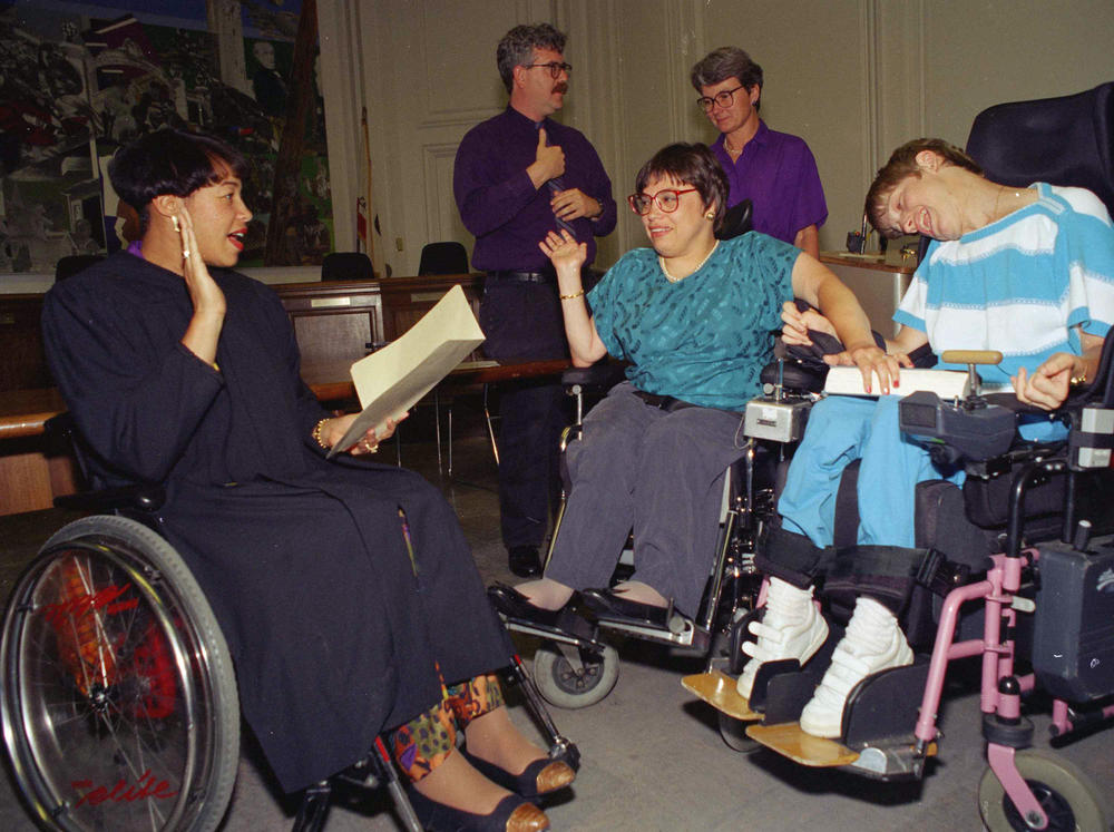 Judy Heumann (center) is given an ovation in June 1993 at her swearing in as U.S. Assistant Secretary for Special Education and Rehabilitative Services in Berkeley, Calif.