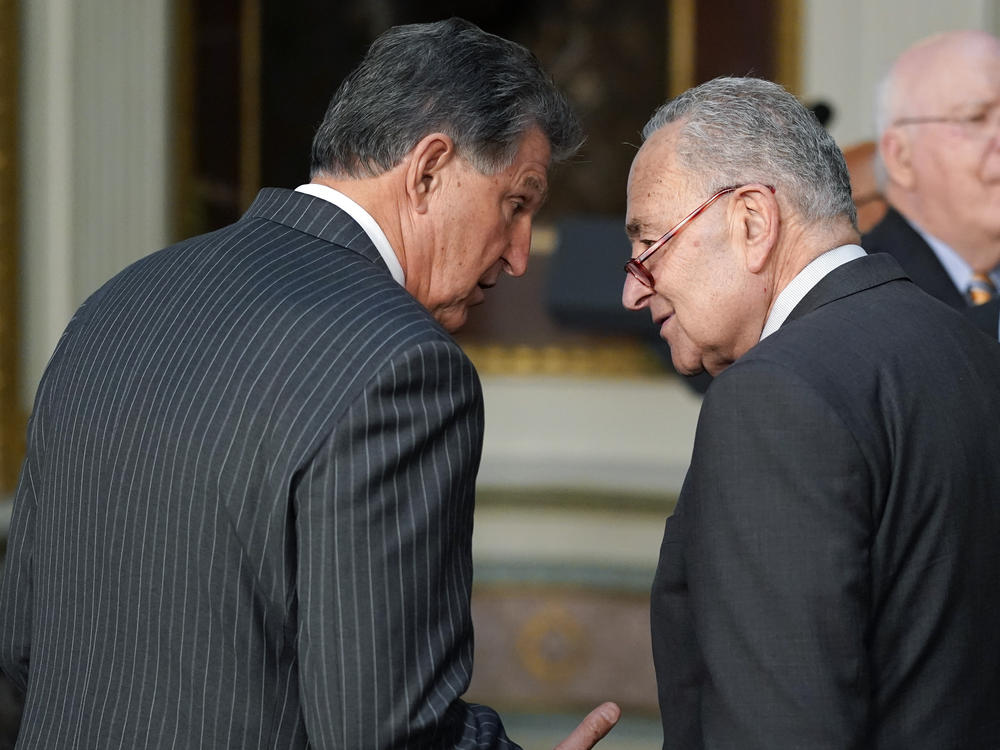 Sen. Joe Manchin, D-W.Va., talks with Senate Majority Leader Chuck Schumer of N.Y., on March 15, 2022.