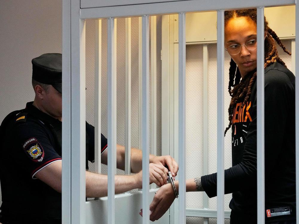 A guard removes Brittney Griner's handcuffs ahead of a hearing at the Khimki Court outside Moscow on Wednesday.