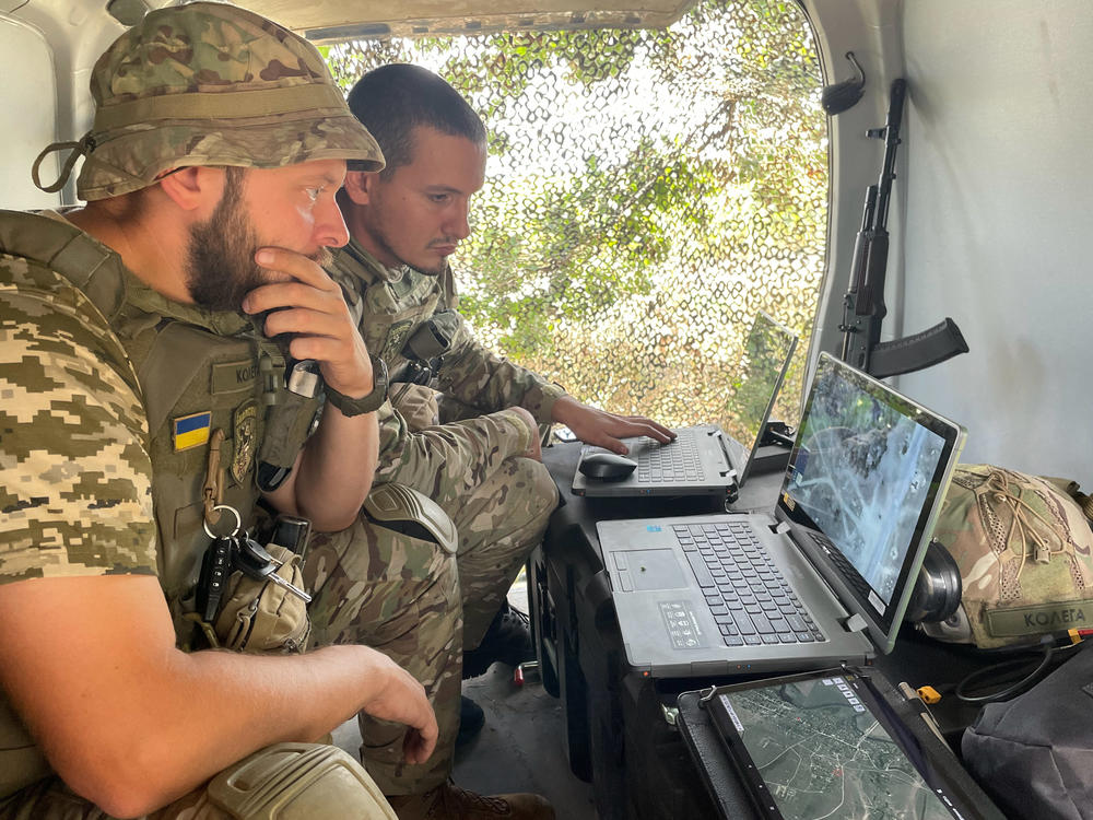 Sacha and one of his drone team colleagues monitor a live video feed from a drone they're flying over a Russian-occupied part of Ukraine.