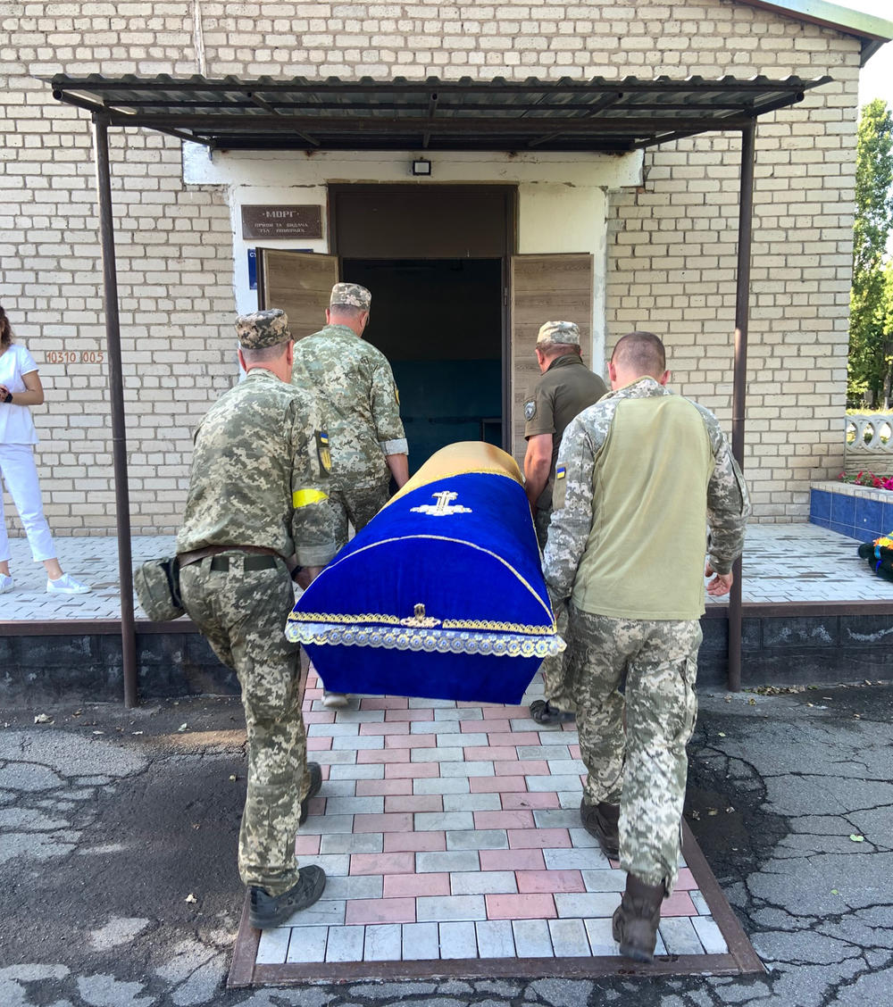 Volunteers carry a coffin.