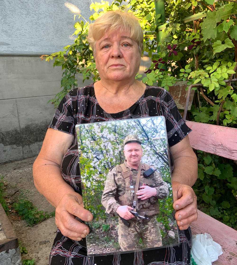 Vira Bilay holds a photo of her late son Andriy Bilay, who worked for the Ukrainian railroad before enlisting to fight. 