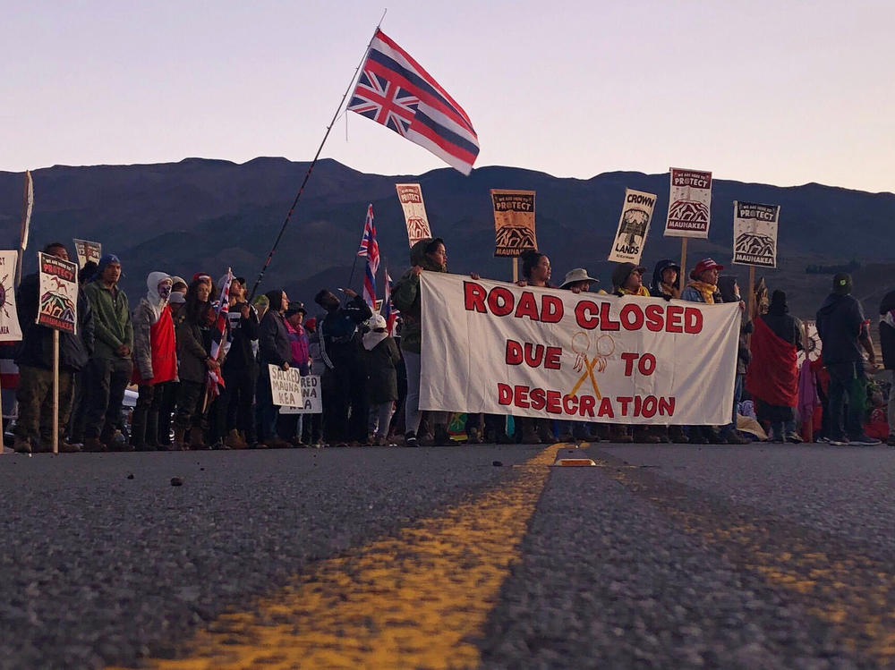 Demonstrators block a road at the base of Mauna Kea in 2019 to protest the construction of the TMT.