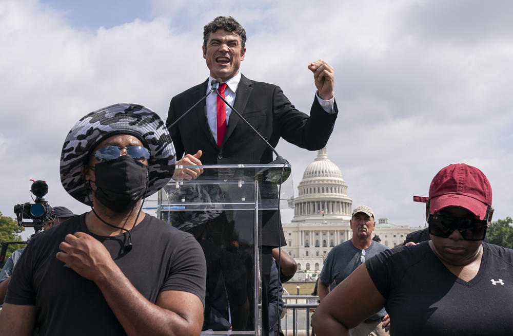 Joe Kent, center, a Trump-endorsed Republican who is challenging Herrera Beutler, speaks during a 
