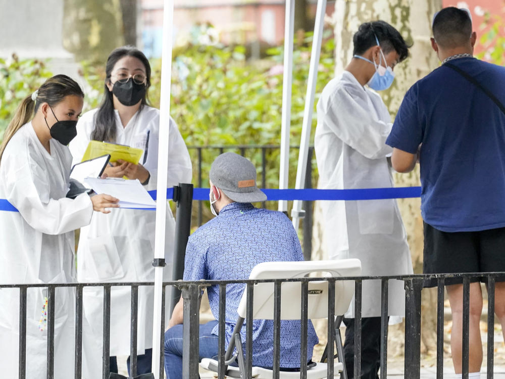 Healthcare workers with New York City Department of Health and Mental Hygiene help people register for the monkeypox vaccine at one of the City's vaccination sites, Tuesday, July 26, 2022, in New York.