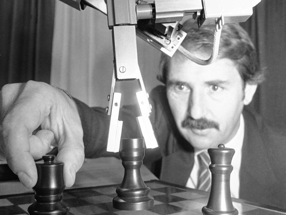 A robot plays a game of chess against a man in 1985.