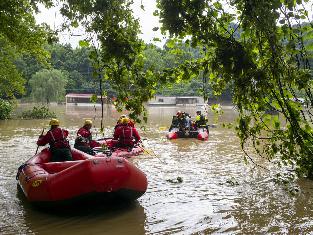 Water rescue teams travel overflowed Troublesome Creek on Friday to rescue people that have been stranded since Wednesday night in Lost Creek, Ky.