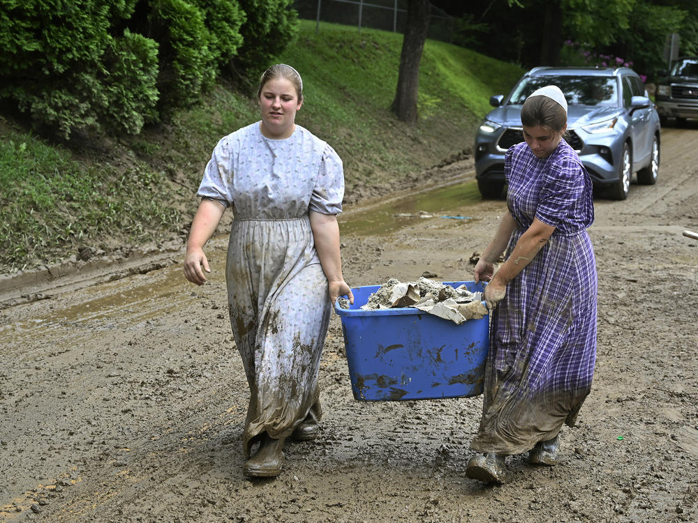 Volunteers from the local Mennonite community carry debris from flood-soaked houses at Ogden Hollar in Hindman, Ky., on Saturday.