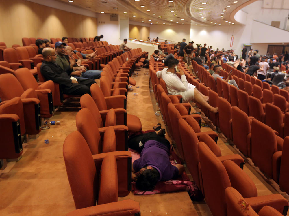 Iraqi protesters rest inside the Parliament building in Baghdad on Sunday. Thousands of followers of an influential Shiite cleric stormed into the building on Saturday, for the second time this week, protesting government formation efforts led by his rivals, an alliance of Iran-backed groups.
