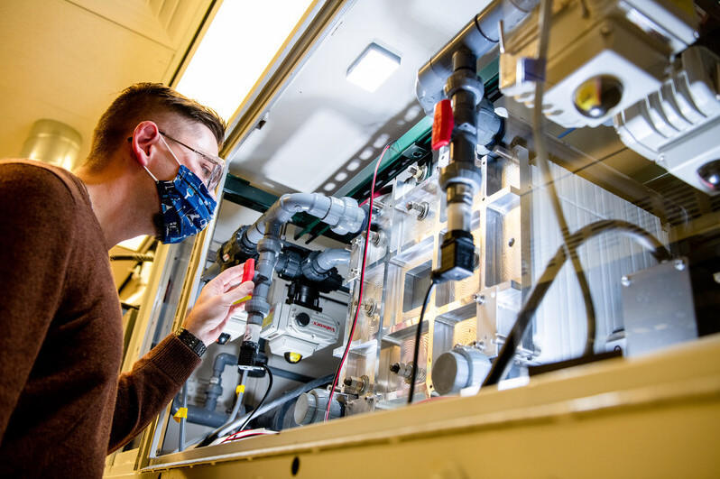 An employee looks at a vanadium flow battery in Pacific Northwest National Laboratory's Battery Reliability Laboratory in 2021.