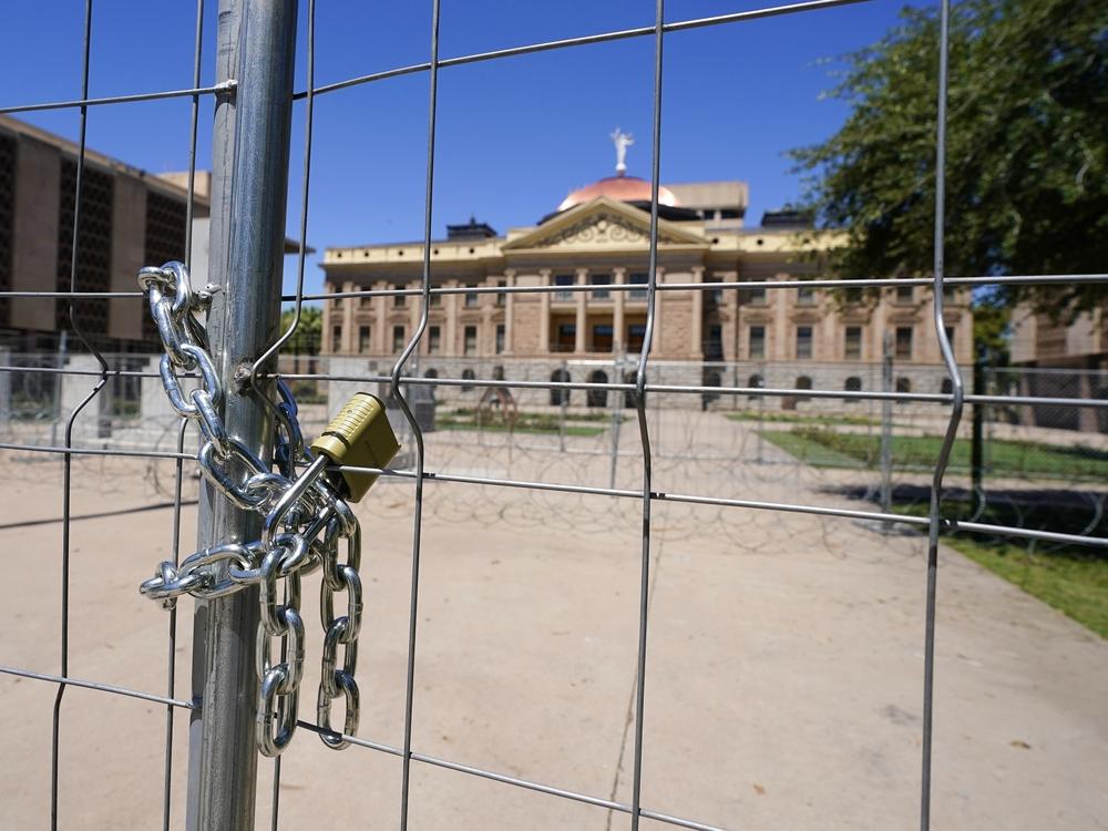 After multiple nights of abortion-rights protests, security fences and barbed wire surround the Arizona Capitol, Monday, June 27, 2022, in Phoenix.