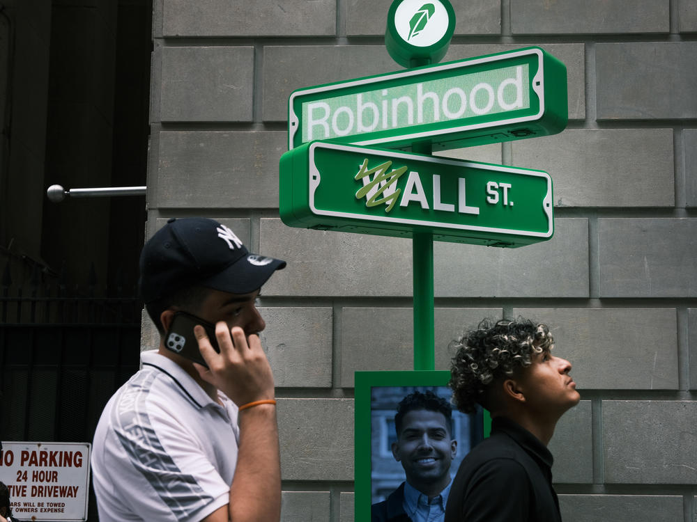 People wait in line for T-shirts at a pop-up kiosk for the online brokerage Robinhood in New York City after the company went public on July 29, 2021. On Tuesday, the company said it was cutting nearly a quarter of its staff.