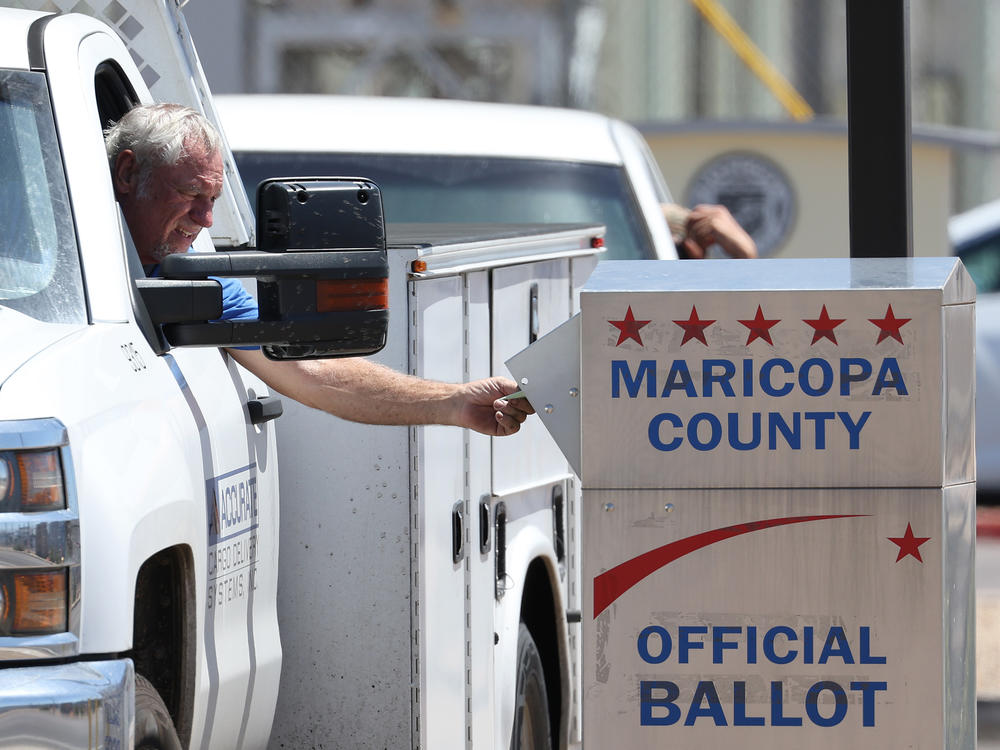 A voter places a ballot in a drop box outside of the Maricopa County Elections Department on August 02, 2022 in Phoenix, Arizona. Arizonans are voting in the state's midterm primary election.