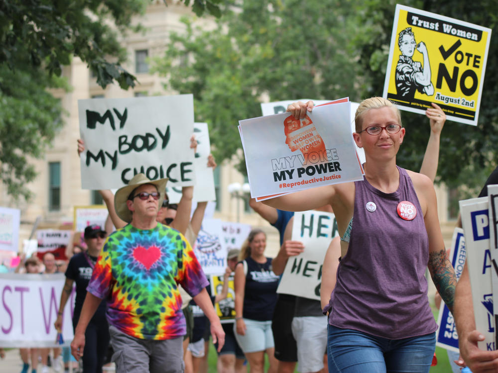 Protesters who oppose a state constitutional amendment that would remove the right to abortion in Kansas march around the Kansas Statehouse in Topeka.