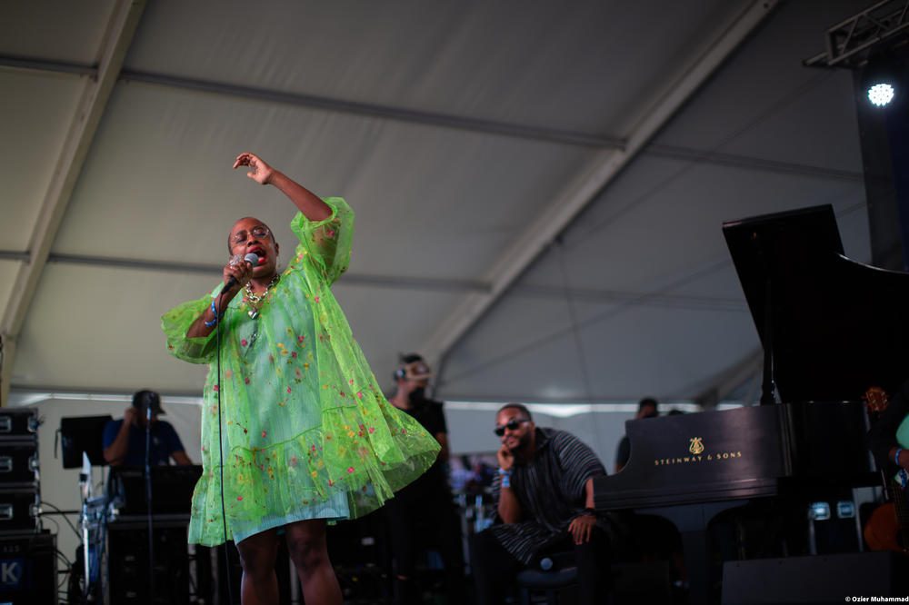 Cécile McLorin Salvant performs onstage, with Sullivan Fortner in the background.